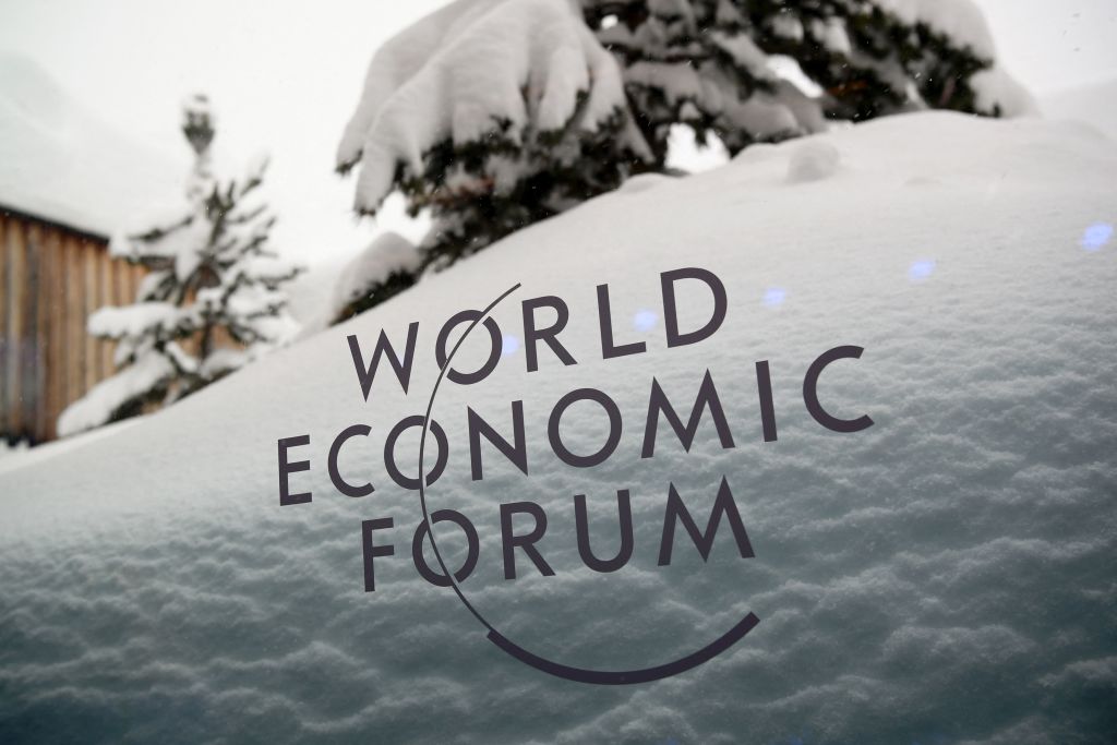 A picture taken on January 21, 2018 shows the logo of the World Economic Forum (WEF) under the snow on the eve of the opening day of the WEF 2018 annual meeting in Davos. - The participation of US President at the World Economic Forum in Davos next week could be thrown into question now that the federal government has partially shut down over budget wrangling, the White House said on January 20. (Photo by Fabrice COFFRINI / AFP) (Photo by FABRICE COFFRINI/AFP via Getty Images)